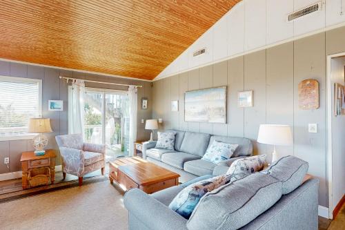 a living room with two couches and a wooden ceiling at Sea Escape 25 in Avon