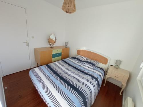 une petite chambre avec un lit et un miroir dans l'établissement Gîte Le Coquillage, 50m de la mer, à Saint-Germain-sur-Ay