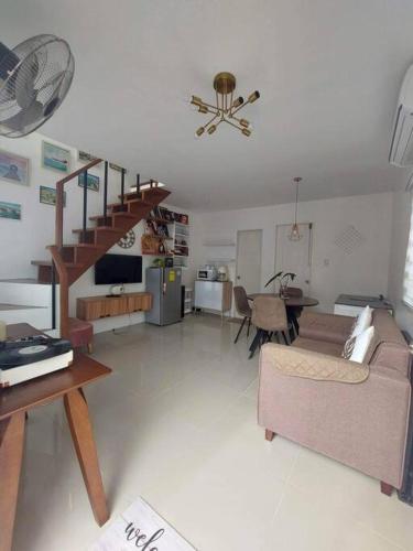 ein Wohnzimmer mit einer Treppe, einem Sofa und einem Tisch in der Unterkunft Cosy House in Bacolod City in Bacolod City
