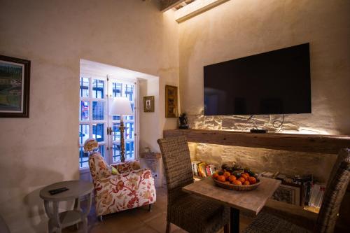 a living room with a fireplace with a flat screen tv at Apartamentos Sharis in Jerez de la Frontera