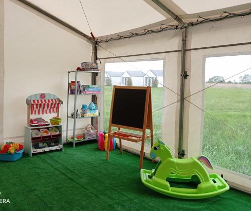 a room with green carpet and a play room with a tent at Strefa Kampinos in Brochów