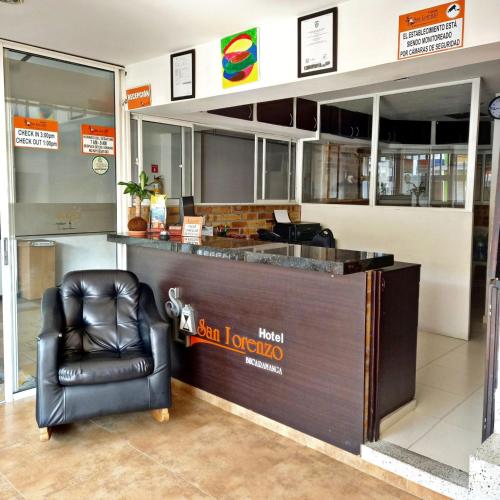 a bar with a leather chair in front of it at Hotel San Lorenzo in Bucaramanga