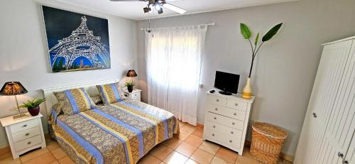 a bedroom with a bed and a tv on a dresser at Ferienhaus CALETA SUEÑO in La Guirra