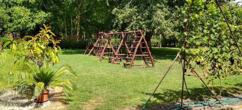 a wooden frame in a yard with a playground at Tassi Halászcsárda-Harcsa ház in Tass