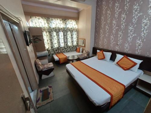 a hotel room with a large bed and a window at Kailash Hotel in Jaipur