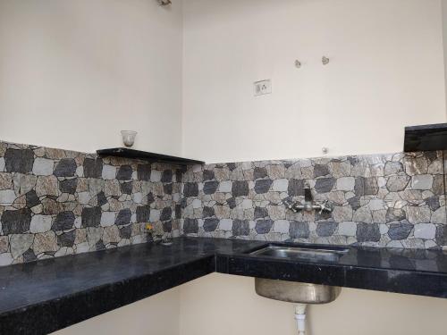 a kitchen with a sink and a tiled wall at House No 87A in Jaipur