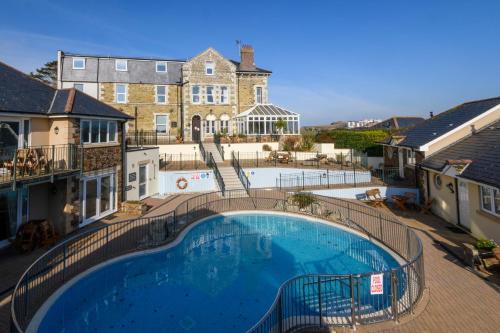a large swimming pool in front of a building at Porth Veor Manor Villas & Apartments in Newquay