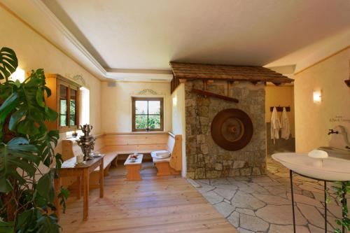 a large living room with a stone fireplace at Villa Ortensia in San Vigilio Di Marebbe
