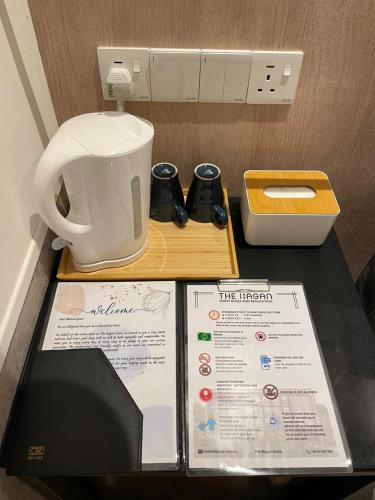 a table with a coffee maker and a menu at Bagan Suite in Butterworth