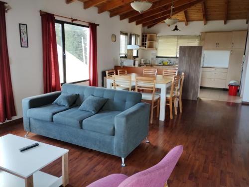 ein Wohnzimmer mit einem blauen Sofa und einem Tisch in der Unterkunft Casa Centro Bariloche in San Carlos de Bariloche