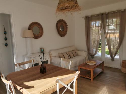 a living room with a table and a couch at La Petite Etoile in Andernos-les-Bains