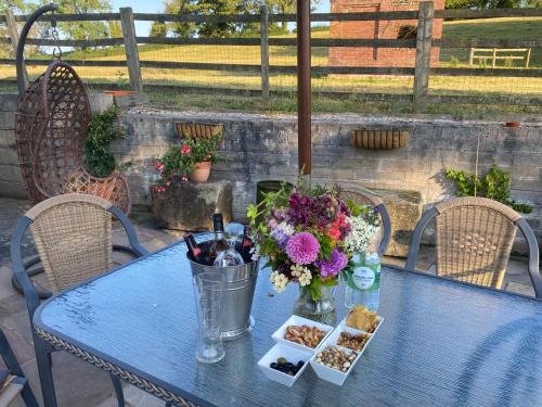 une table bleue avec un vase de fleurs et de biscuits dans l'établissement The Bay Tree, à Alton