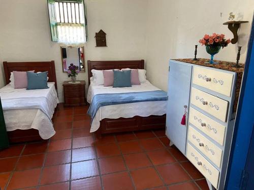 a room with two beds and a dresser in it at Villa Isabel in Guaduas