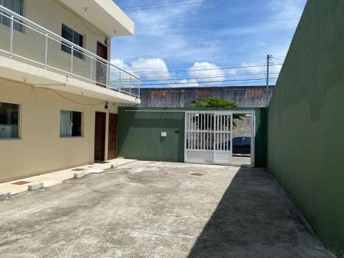 um edifício com uma garagem com uma porta branca em Cabo Frio - Braga - Kitnets - Aluguel Econômico em Cabo Frio