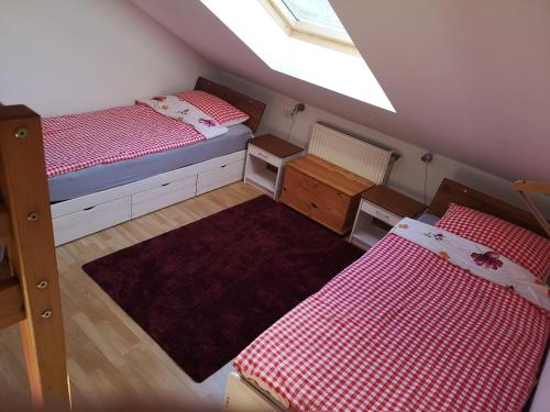 ザンクト・ブラージエンにあるFerienwohnung Haus Maria Schwarzwaldの屋根裏のベッドルーム(ベッド2台、窓付)