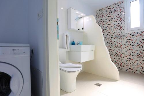 a bathroom with a toilet and a sink and a mirror at Xenos Villa 7 with a Private pool near the sea in Tigaki