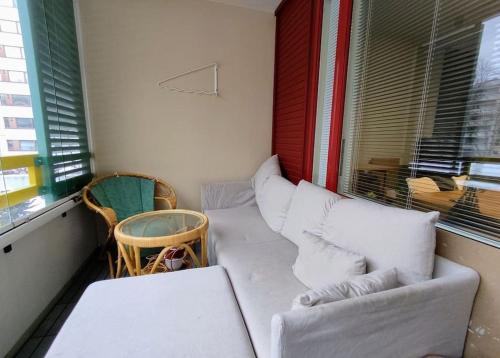 una pequeña sala de estar con sofá y ventana en Cosy Big 2 room apartment, en Helsinki