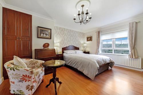 1 dormitorio con 1 cama, 1 silla y 1 lámpara de araña en Gormley Residence en Cottian