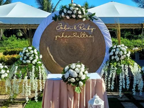 a large welcoming sign for a wedding ceremony with flowers at Calicoan Villa in Sarog
