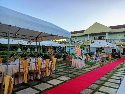 an outdoor wedding with tables and chairs on a red carpet at Calicoan Villa in Sarog