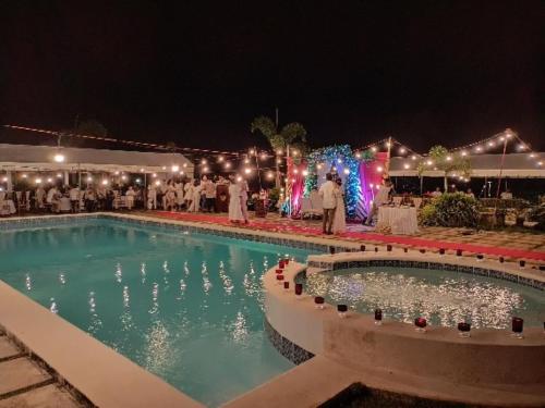 a swimming pool at night with people standing around it at Calicoan Villa in Sarog