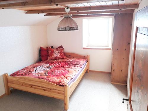 a bedroom with a bed with red pillows and a window at Ferienhaus Signina in Danis