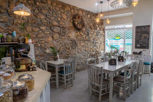 um restaurante com mesas e cadeiras e uma parede de pedra em Althaia Pension em Nafplio