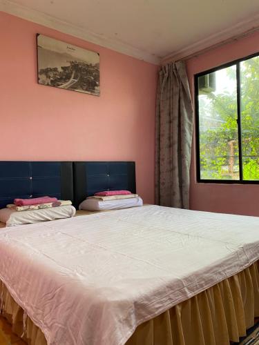 a bedroom with two beds and a window at Muna’s Homestay in Kota Belud