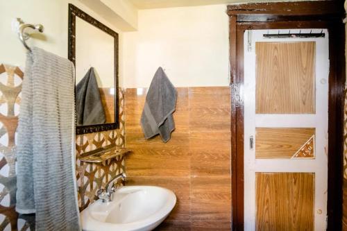 a bathroom with a sink and a mirror at Folktales Residency in Saturang