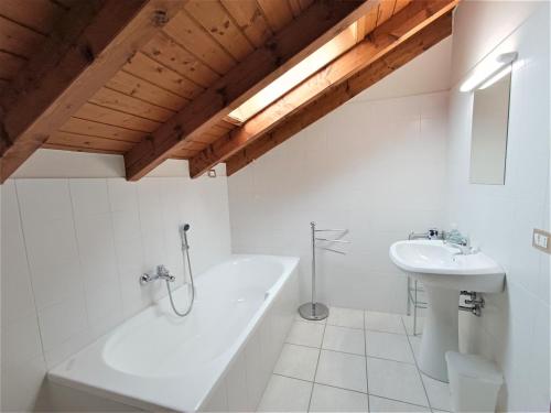 Un baño blanco con bañera y lavabo. en Via Panoramica, en Baveno