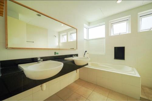 uma casa de banho com 2 lavatórios e um espelho grande em Nautilus Bay Home Inn em George Town