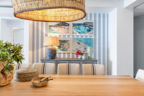 a dining room with a table and a chandelier at The Nici Clifton Sea View Apartments in Cape Town