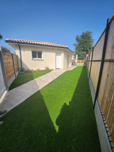 une cour avec une clôture et une maison dans l'établissement CHEZ CED - Gujan-Mestras / Bassin d'Arcachon, à Gujan-Mestras