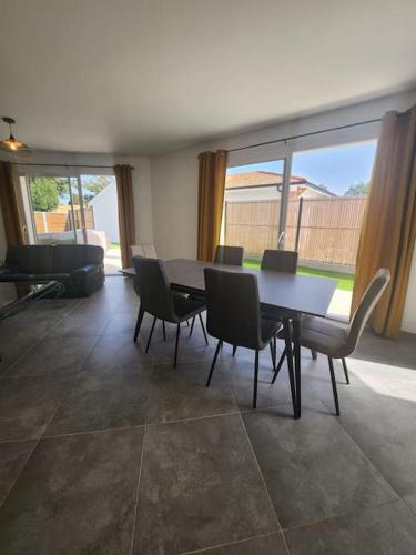 une salle à manger avec une table, des chaises et un canapé dans l'établissement CHEZ CED - Gujan-Mestras / Bassin d'Arcachon, à Gujan-Mestras