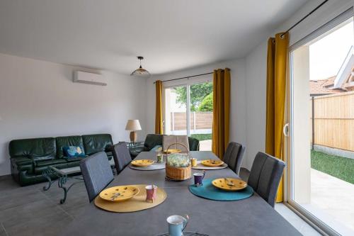 uma sala de estar com uma mesa e um sofá em CHEZ CED - Gujan-Mestras / Bassin d'Arcachon em Gujan-Mestras