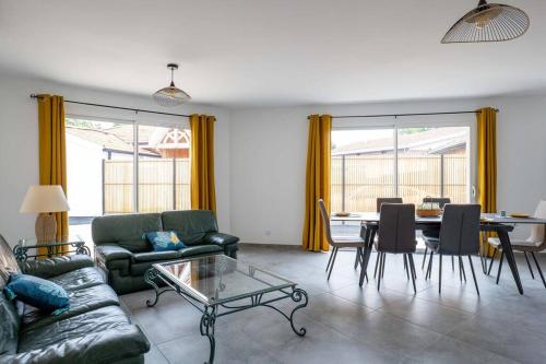 ein Wohnzimmer mit einem Sofa und einem Tisch in der Unterkunft CHEZ CED - Gujan-Mestras / Bassin d'Arcachon in Gujan-Mestras