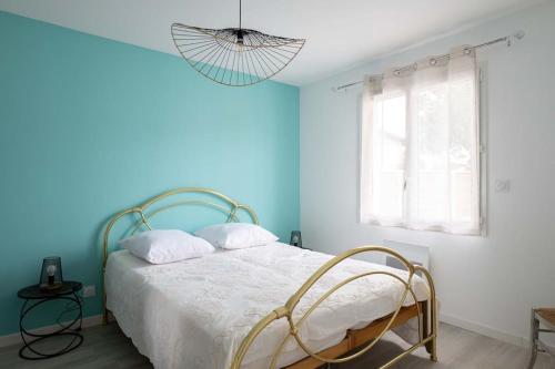 - une chambre avec des murs bleus et un lit avec une chaise en osier dans l'établissement CHEZ CED - Gujan-Mestras / Bassin d'Arcachon, à Gujan-Mestras