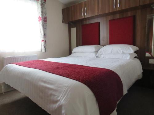 a bedroom with a large bed with a red headboard at alphi3 in Bude