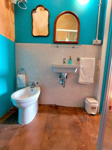 a bathroom with a sink and a toilet and a mirror at Alloggi Turistici Boccetta 27 in Cerveteri