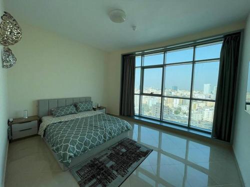 a bedroom with a bed and a large window at Luxery home with stunning sea view in Ajman 