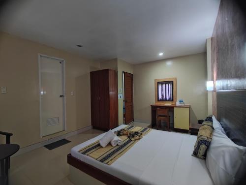 a bedroom with a bed and a desk and a mirror at Calicoan Villa in Sarog