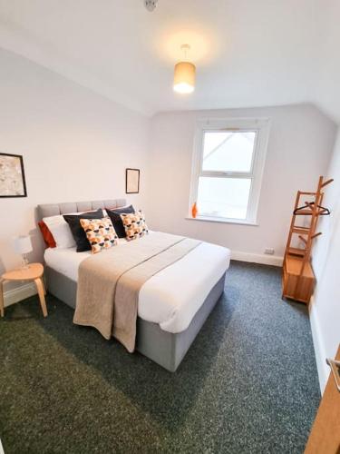a bedroom with a bed and a window at Stunning Flat Close to Beach in Swansea