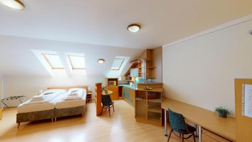 sypialnia z łóżkiem i biurkiem z krzesłami w obiekcie Apartments Kroměříž w Kromieryżu