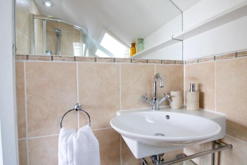 a bathroom with a sink and a mirror at Cormorant- Sea View, Couples Retreat in Brixham