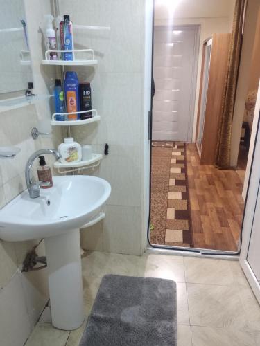 y baño con lavabo blanco y ducha. en уют en Rustavi