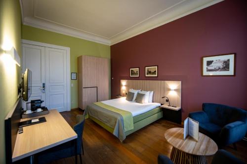 a hotel room with a bed and a table at La Villa des Fleurs in Spa