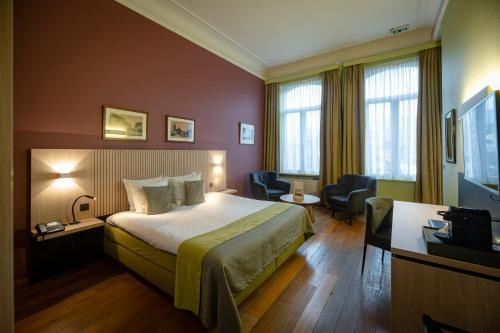een hotelkamer met een bed en een televisie bij La Villa des Fleurs in Spa