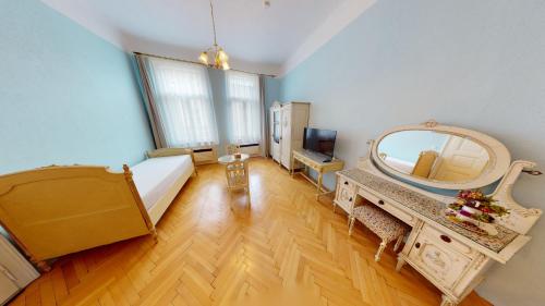 Cette chambre comprend un miroir, un lit et une table. dans l'établissement Apartments Kroměříž, à Kroměříž