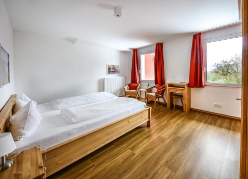 a bedroom with a large bed and red curtains at Hotel Lafette in Hinterzarten