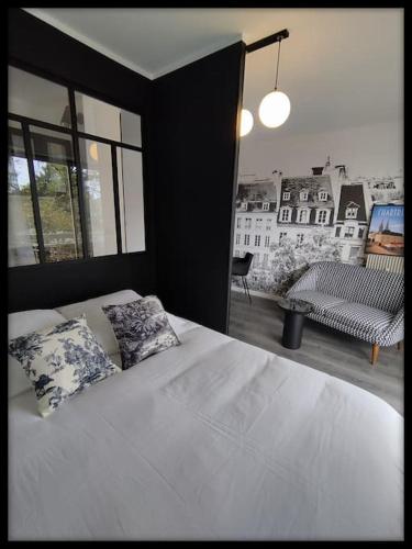 une chambre avec un grand lit blanc avec deux oreillers dans l'établissement Le p'tit Beauce au Cœur de Chartres, à Chartres